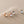 Set of four earrings on a beige surface