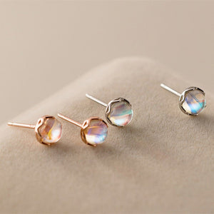 Set of four earrings on a beige surface