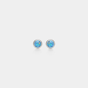 Pair of silver stud earrings with blue opal stones on a light gray background