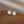 Pair of silver floral earrings on a brown surface