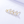 Gold earrings with clear gemstones on a light gray background