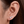 Close-up of an ear wearing two diamond stud earrings with a blurred background
