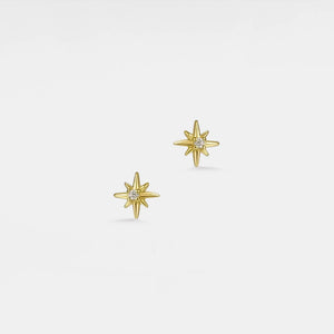Gold star-shaped earrings on a light gray background