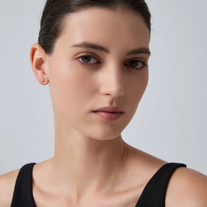 Close-up of a woman's face with a neutral expression on a gray background