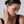 Woman wearing a gold earring on a plain background