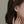Star-shaped earring worn by a person with dark hair and beige nail polish.