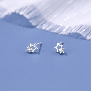 Star-shaped silver earrings on a light blue background