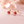 Strawberry-shaped earrings on a soft pink background