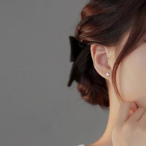 Close-up of a person wearing a star-shaped earring with a blurred background