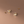 Gold flower-shaped earrings on a brown background