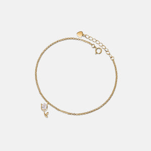 Gold bracelet with charms on a light gray background