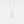 Gold necklace with a small pendant on a light gray background