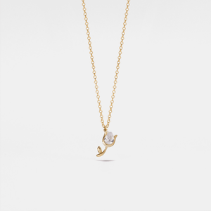 Gold necklace with a small pendant on a light gray background
