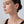 Close-up of a woman wearing earrings on a plain background