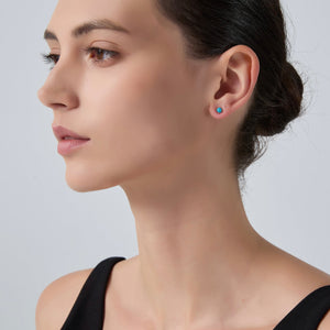 Close-up of a woman wearing earrings on a plain background