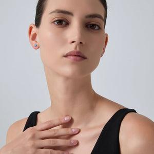Woman wearing a black sleeveless top against a plain background