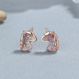 A set of unicorn stud earrings in various colors including silver and rose gold, featuring multicolored stones.