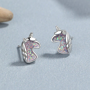 A set of unicorn stud earrings in various colors including silver and rose gold, featuring multicolored stones.
