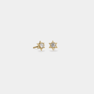 Gold star-shaped earrings with clear gemstones on a light gray background