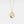 Gold necklace with a circular pendant featuring a blue gemstone on a light gray background
