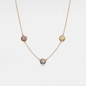 A gold-plated necklace with three circular photo projection pendants on a white background.