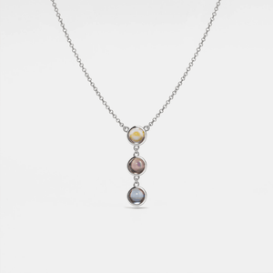 A silver necklace with gold plating featuring three round crystal glass pendants in a gradient of colors, suspended from a gold-plated chain.