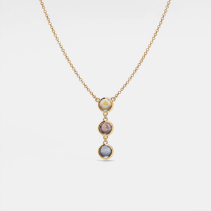 A silver necklace with gold plating featuring three round crystal glass pendants in a gradient of colors, suspended from a gold-plated chain.