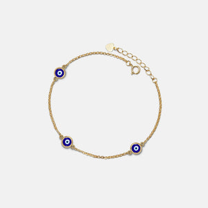 Gold bracelet with blue evil eye charms on a light gray background