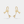 Gold bow-shaped earrings on a light gray background