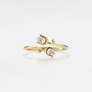 Gold ring with two diamond stones on a white background