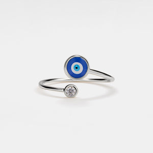 Silver ring with blue evil eye design on a white background