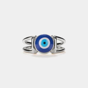 A silver-colored statement cocktail ring with a blue enamel evil eye design on a white background.