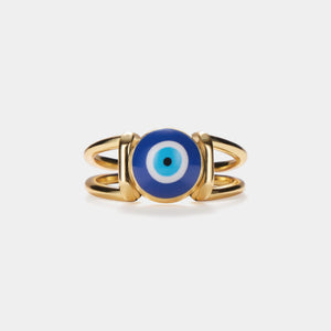 A gold-colored statement cocktail ring with a blue enamel evil eye design on a white background.