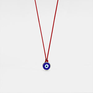 A red rope necklace with a blue circular charm representing the evil eye, hypoallergenic gold plating, and made from 925 sterling silver.