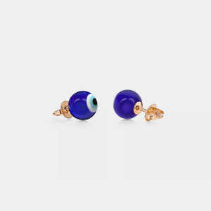A pair of stud earrings featuring a blue 'evil eye' design on a white background