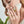 Woman wearing a ring with blue evil eye charms on a light gray background