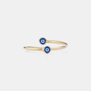 Gold ring with blue evil eye charms on a light gray background