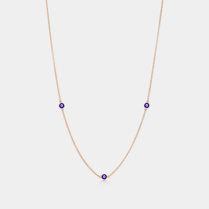 A gold-plated necklace with three blue enamel charms representing the evil eye, designed to be worn around the neck.
