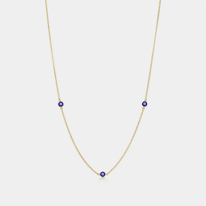 Gold necklace with blue evil eye charms on a white background