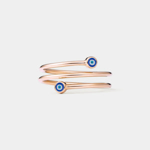 Rose gold three row ring with blue evil eye charms on a light gray background