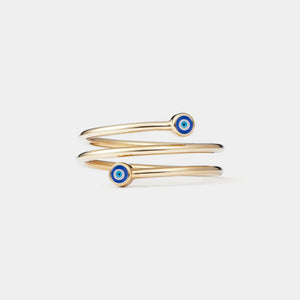 Gold three row ring with blue evil eye charms on a light gray background