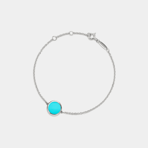 A white gold-plated sterling silver bracelet with a turquoise locket in the center, featuring a chain that is adjustable.