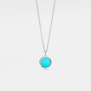 Silver necklace with a turquoise locket on a light gray background