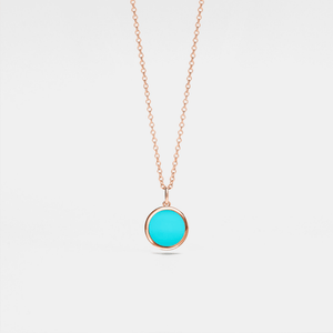 Rose gold necklace with a turquoise locket on a light gray background