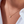 Gold necklace with a small pendant on a person wearing a white shirt.