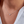 Necklace with a heart-shaped pendant worn by a person wearing a white shirt.