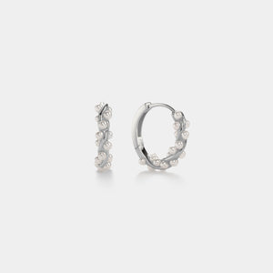 Silver hoop earrings with small pearls on a light gray background