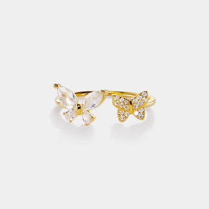 Gold butterfly ring with clear gemstones on a white background