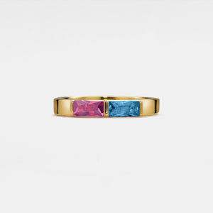 Gold ring with pink and blue gemstones on a white background