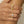 Close-up of a hand wearing two gold rings with floral designs on a neutral background